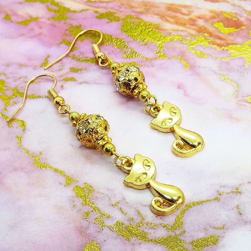 マットゴールドの猫のチャームとキラキラ光るガラス入りのメタルビースのピアス