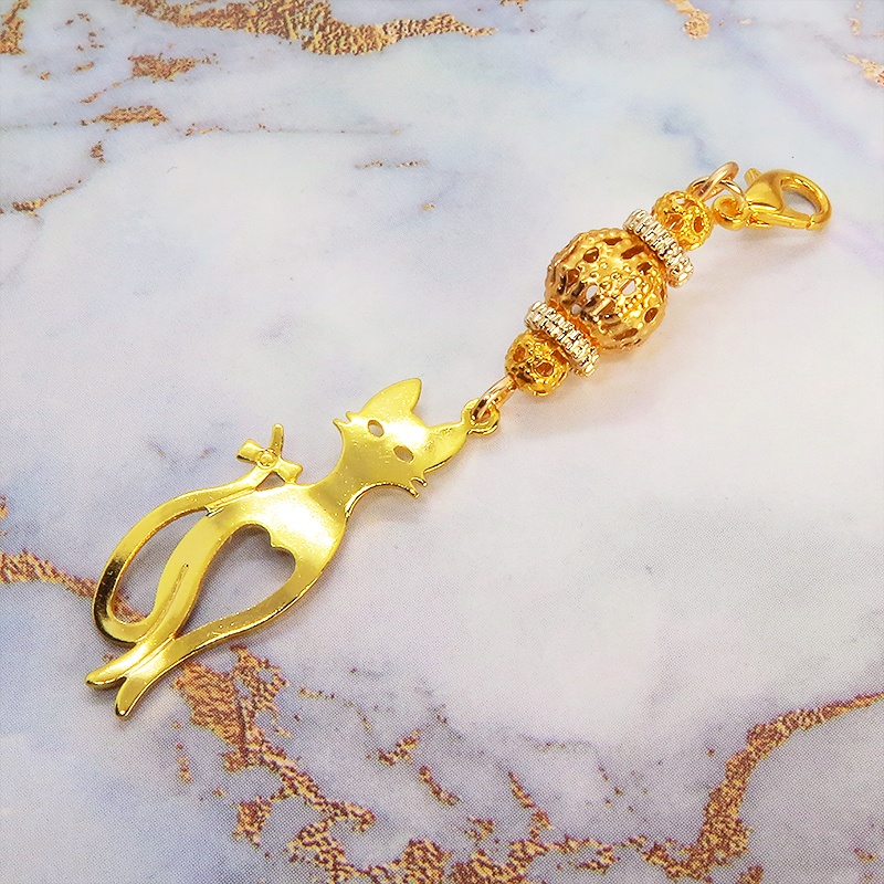 マスクチャーム ゴールドカラーのスマートな猫シルエットモチーフと大きめメタルビーズのチャーム