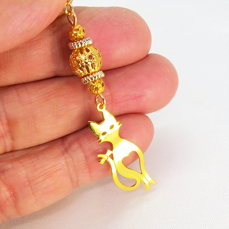 マスクチャーム ゴールドカラーのスマートな猫シルエットモチーフと大きめメタルビーズのチャーム