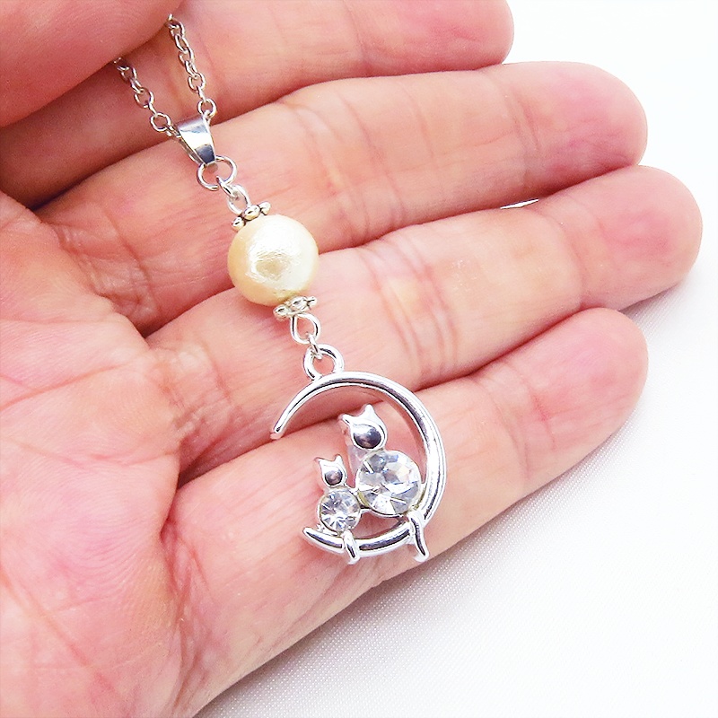猫の親子が三日月のうえで寄り添うモチーフのネックレス シルバーカラー コットンパール ラインストーン