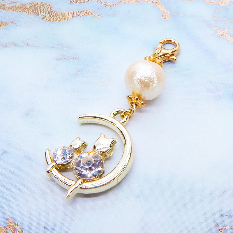 マスクチャーム 猫の親子が三日月で寄添うゴールドカラーのモチーフとコットンパールのチャーム ラインストーン キーホルダー