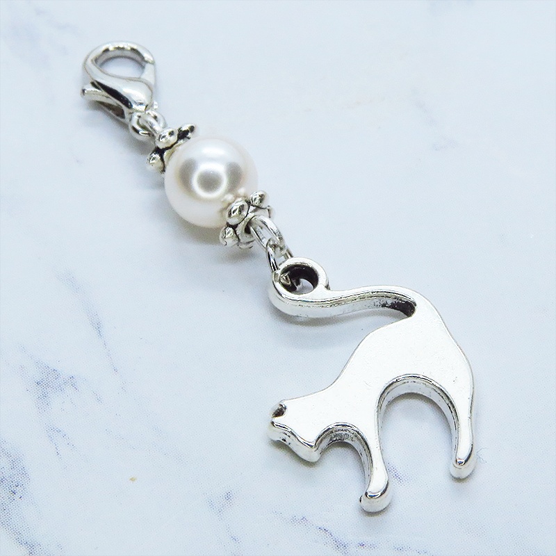 マスクチャーム アンティークシルバーの跳ね猫モチーフとスワロフスキーパール(クリスタルホワイト)のチャーム  キーホルダー