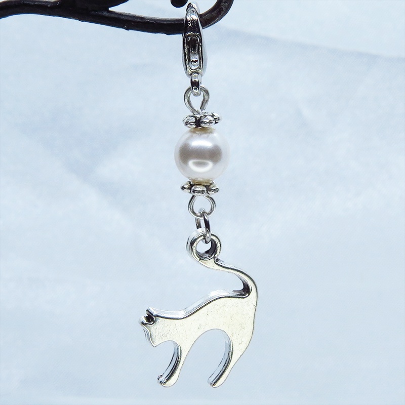 マスクチャーム アンティークシルバーの跳ね猫モチーフとスワロフスキーパール(クリスタルホワイト)のチャーム  キーホルダー