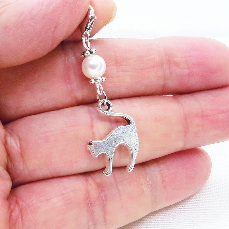 マスクチャーム アンティークシルバーの跳ね猫モチーフとスワロフスキーパール(クリスタルホワイト)のチャーム  キーホルダー