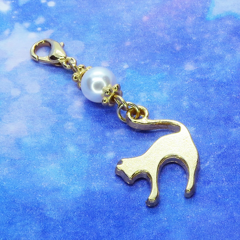 マスクチャーム マットゴールドの跳ね猫モチーフとスワロフスキーパール(クリスタルホワイト)のチャーム キーホルダー