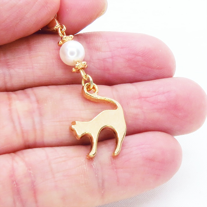 マスクチャーム マットゴールドの跳ね猫モチーフとスワロフスキーパール(クリスタルホワイト)のチャーム キーホルダー