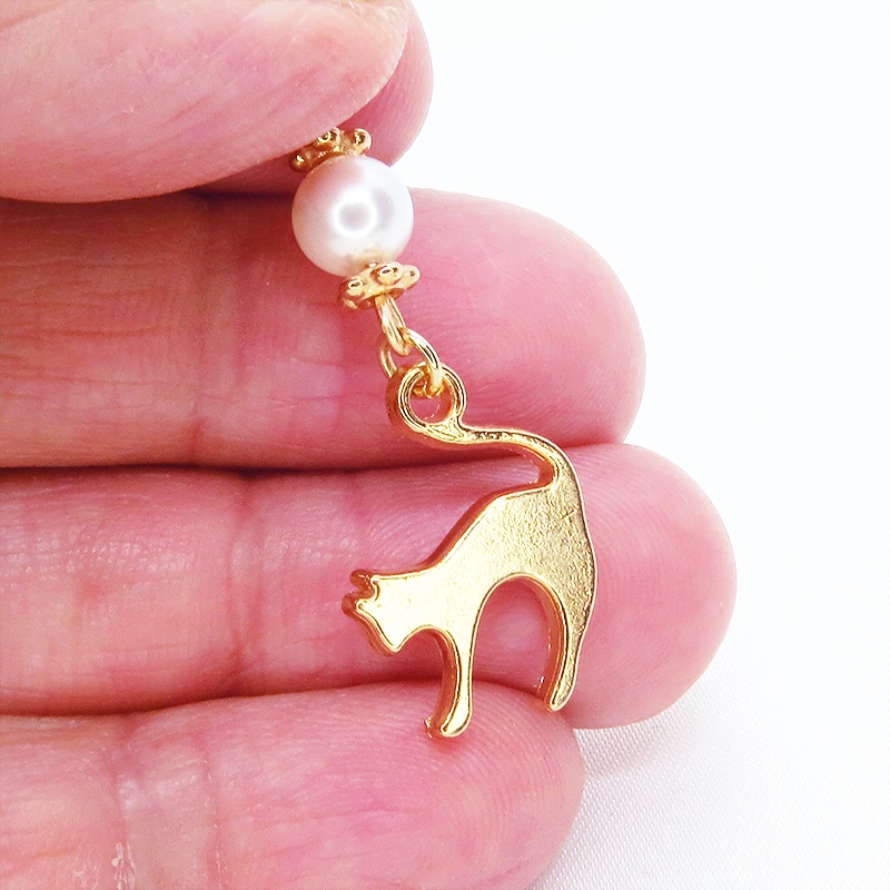 マスクチャーム マットゴールドの跳ね猫モチーフとスワロフスキーパール(クリスタルホワイト)のチャーム キーホルダー