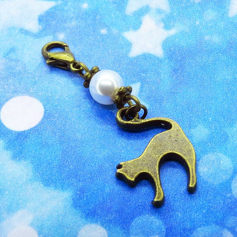 マスクチャーム アンティークカラーの跳ね猫モチーフとスワロフスキーパール(クリスタルホワイト)のチャーム キーホルダー