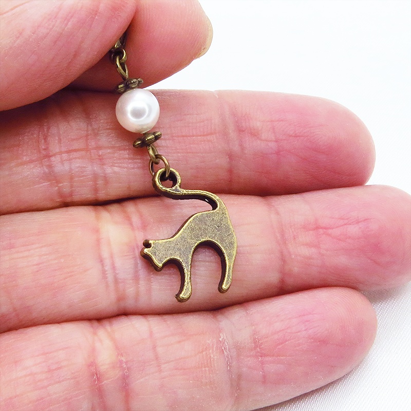 マスクチャーム アンティークカラーの跳ね猫モチーフとスワロフスキーパール(クリスタルホワイト)のチャーム キーホルダー