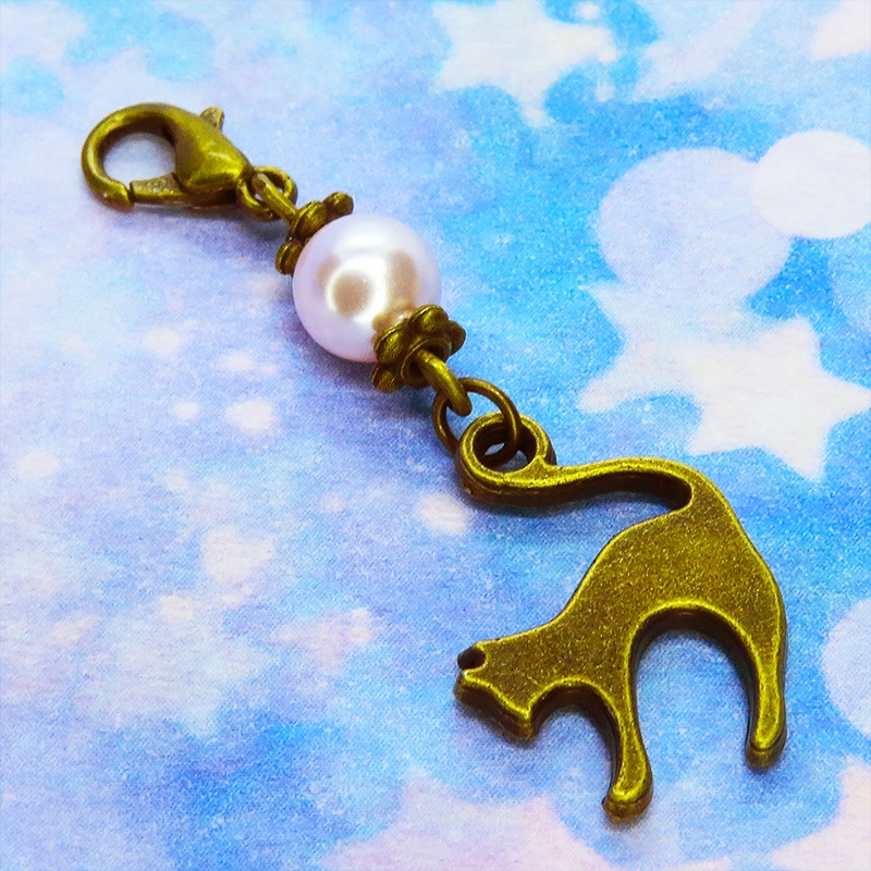 マスクチャーム アンティークカラーの跳ね猫モチーフとスワロフスキーパール(ロザリン)のチャーム キーホルダー