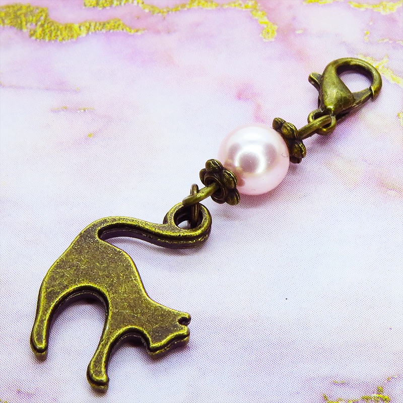 マスクチャーム アンティークカラーの跳ね猫モチーフとスワロフスキーパール(ロザリン)のチャーム キーホルダー