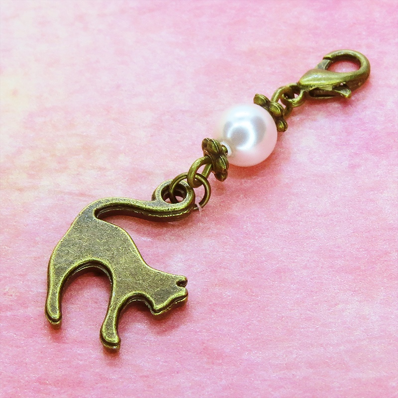 マスクチャーム アンティークカラーの跳ね猫モチーフとスワロフスキーパール(ロザリン)のチャーム キーホルダー