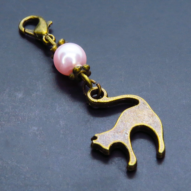 マスクチャーム アンティークカラーの跳ね猫モチーフとスワロフスキーパール(ロザリン)のチャーム キーホルダー