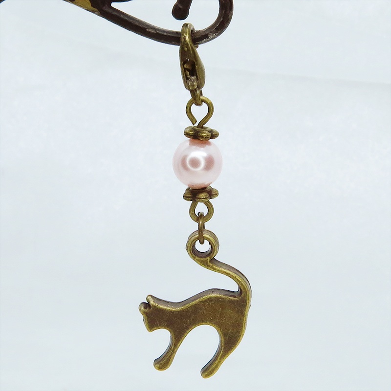 マスクチャーム アンティークカラーの跳ね猫モチーフとスワロフスキーパール(ロザリン)のチャーム キーホルダー