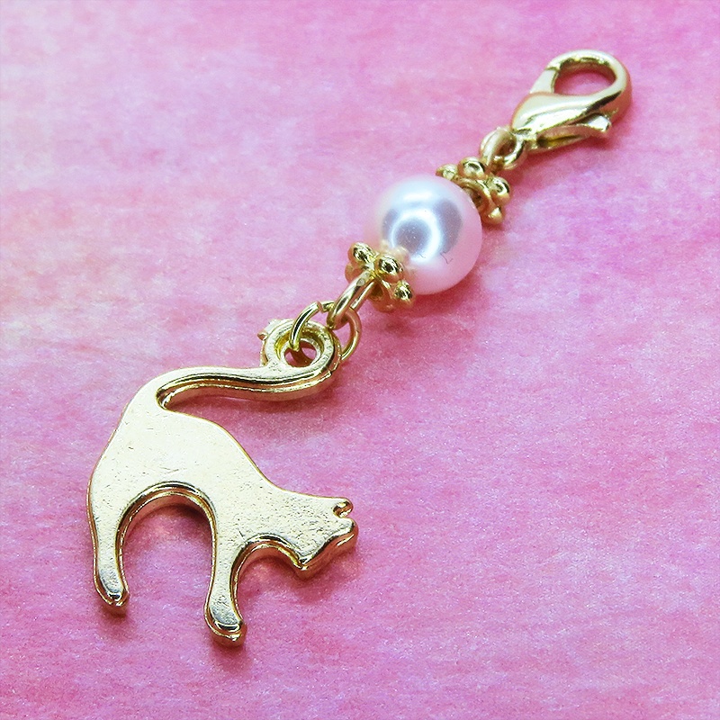 マスクチャーム マットゴールドの跳ね猫モチーフとスワロフスキーパール(ロザリン)のチャーム キーホルダー