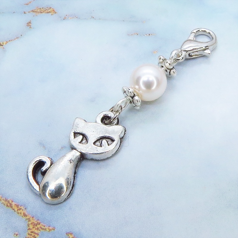 マスクチャーム アンティークシルバーの猫モチーフとスワロフスキーパール(クリスタルホワイト)のチャーム キーホルダー