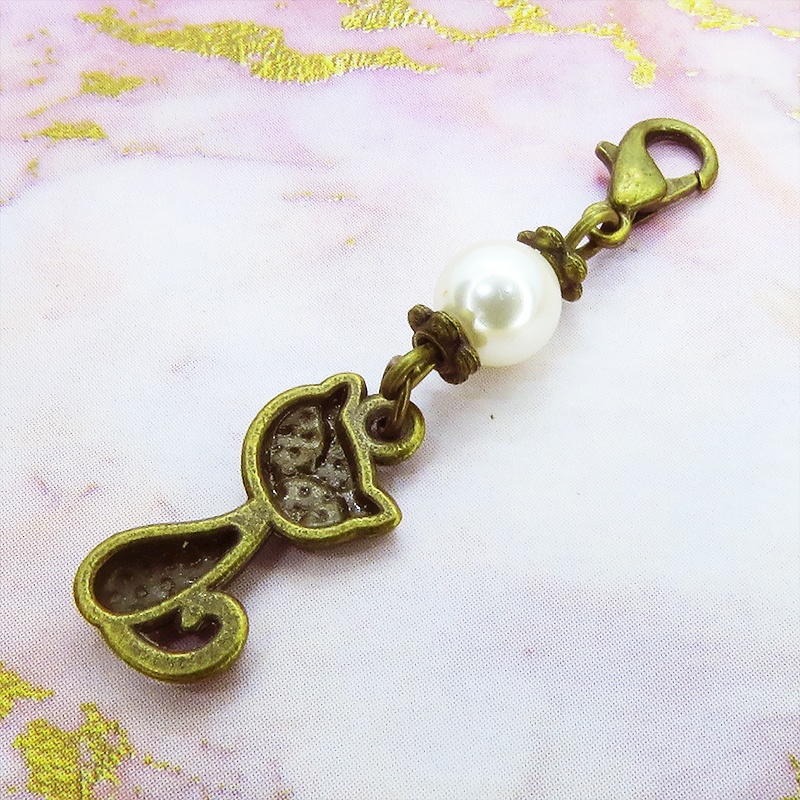 マスクチャーム アンティークカラーの猫モチーフとスワロフスキーパール(クリスタルホワイト)のチャーム キーホルダー