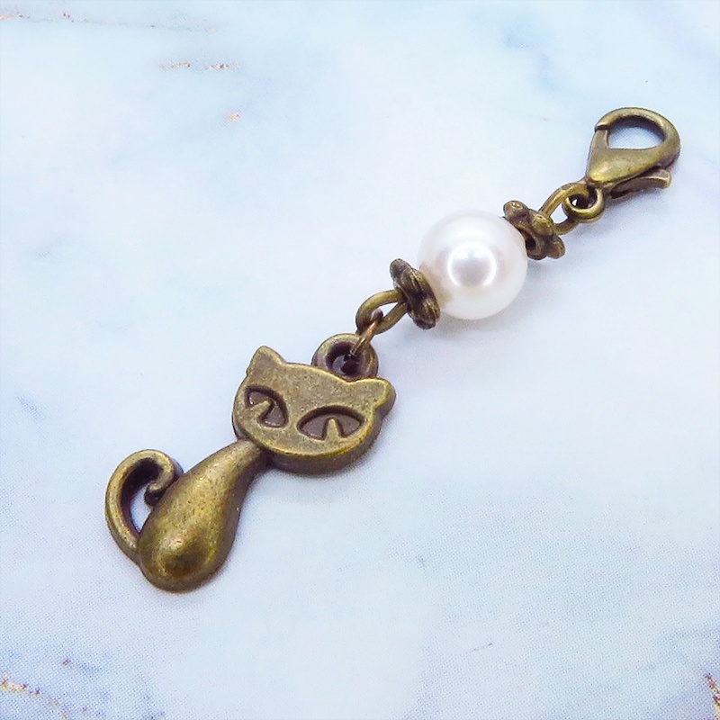 マスクチャーム アンティークカラーの猫モチーフとスワロフスキーパール(クリスタルホワイト)のチャーム キーホルダー
