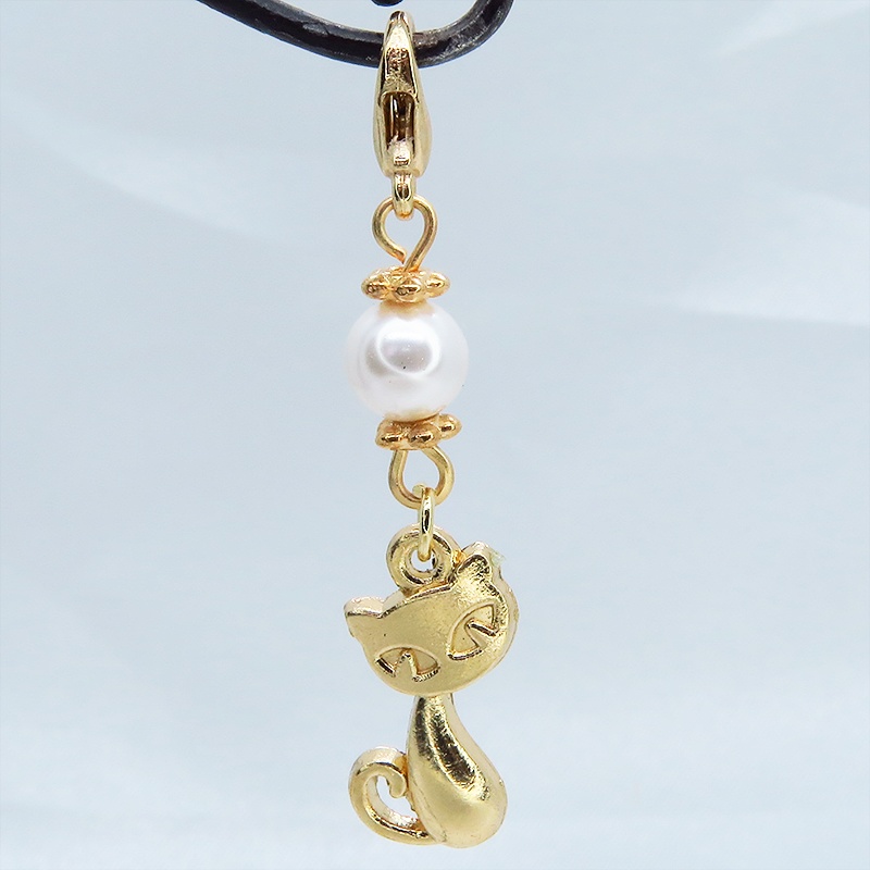 マスクチャーム マットゴールドの猫モチーフとスワロフスキーパール(クリスタルホワイト)のチャーム キーホルダー