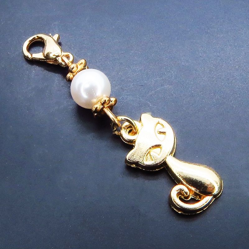 マスクチャーム マットゴールドの猫モチーフとスワロフスキーパール(クリスタルホワイト)のチャーム キーホルダー