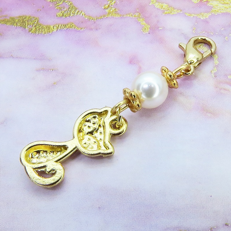 マスクチャーム マットゴールドの猫モチーフとスワロフスキーパール(クリスタルホワイト)のチャーム キーホルダー