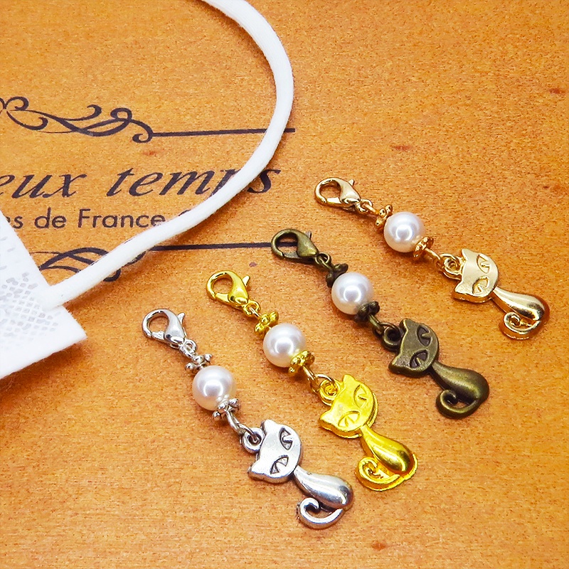 マスクチャーム マットゴールドの猫モチーフとスワロフスキーパール(クリスタルホワイト)のチャーム キーホルダー