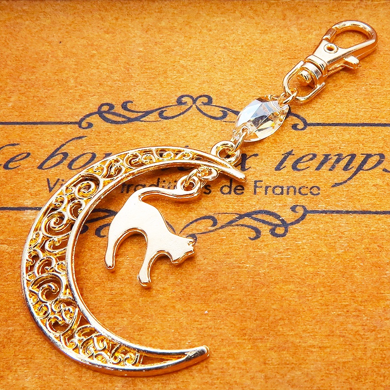 マットゴールドの跳ね猫モチーフと透かし三日月のキーホルダー スワロフスキー・クリスタル(ゴールドシャドー)