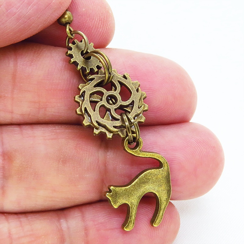 スチームパンク風アンティークカラーの跳ね猫モチーフと歯車のアシンメトリーピアス コンパクトスリム