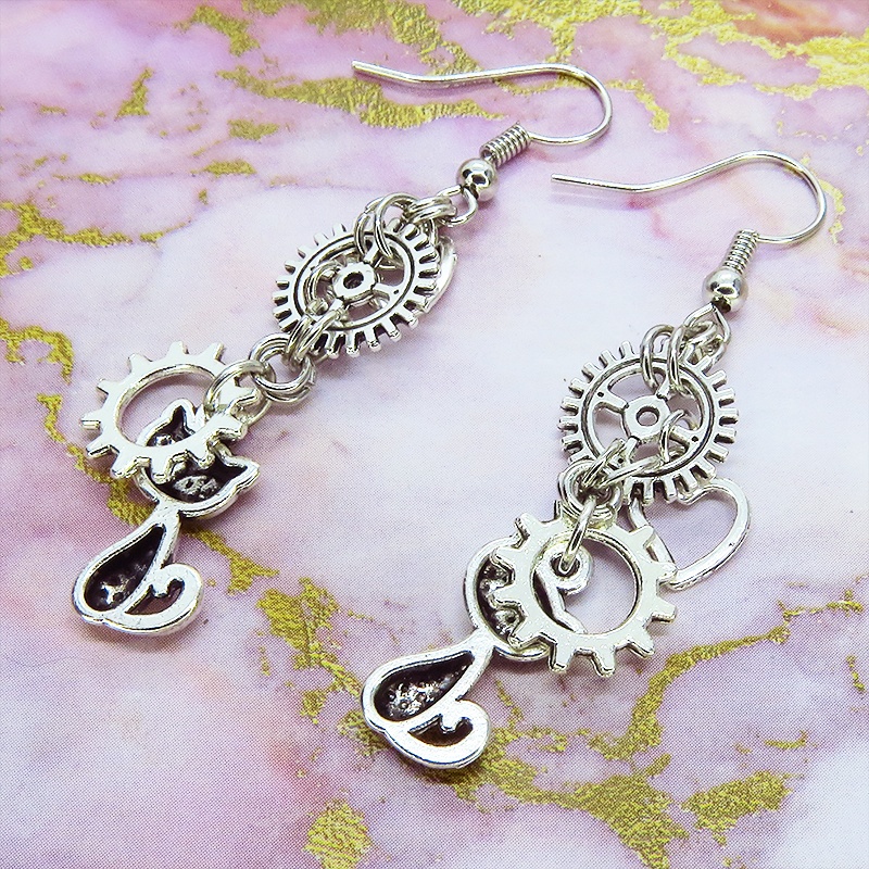アンティークシルバー 猫と異なる歯車を組合せたスチームパンク風ピアス オープンハート サージカル可