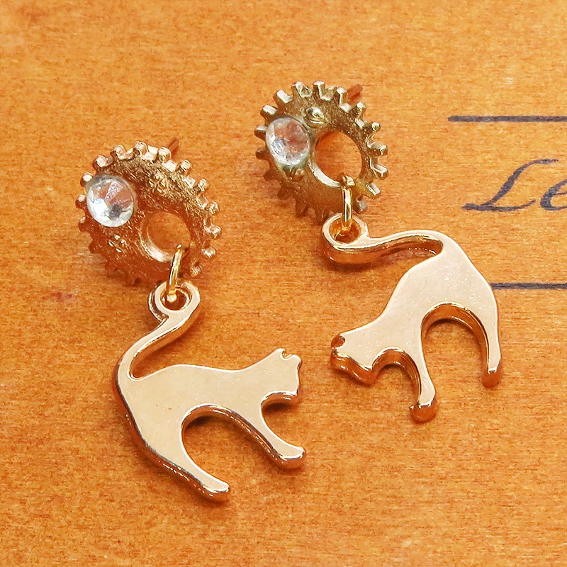 マットゴールドの跳ね猫モチーフと歯車のスチームパンク風スタッドピアス クリスタルガラス
