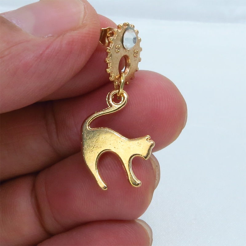 マットゴールドの跳ね猫モチーフと歯車のスチームパンク風スタッドピアス クリスタルガラス