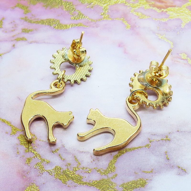 マットゴールドの跳ね猫モチーフと歯車のスチームパンク風スタッドピアス クリスタルガラス