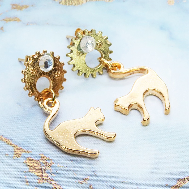 マットゴールドの跳ね猫モチーフと歯車のスチームパンク風スタッドピアス クリスタルガラス