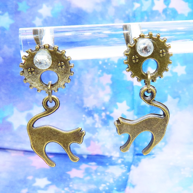 アンティークゴールドの跳ね猫モチーフと歯車のスチームパンク風スタッドピアス クリスタルガラス