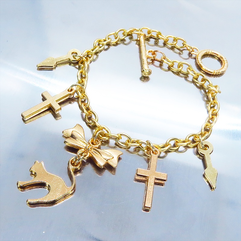 マットゴールドの猫シルエットモチーフとリボンに鍵と時計の針が連なるブレスレット