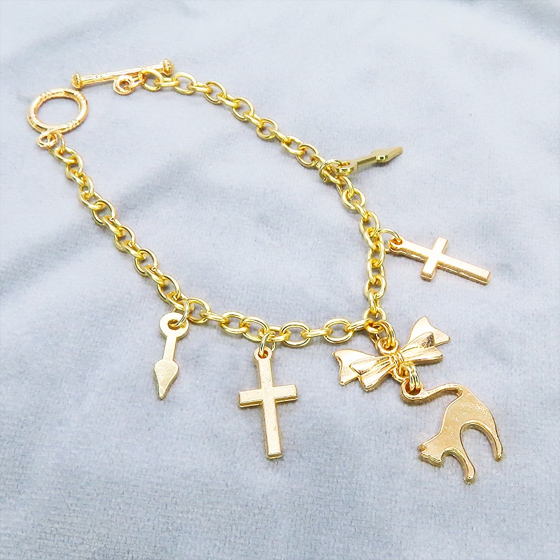 マットゴールドの猫シルエットモチーフとリボンに鍵と時計の針が連なるブレスレット