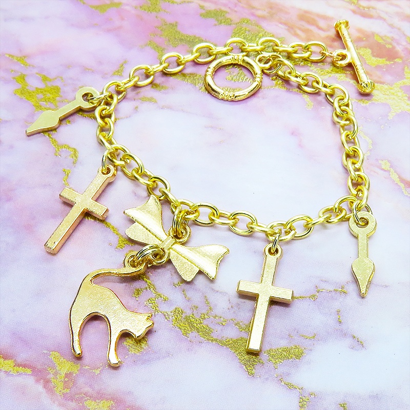 マットゴールドの猫シルエットモチーフとリボンに鍵と時計の針が連なるブレスレット