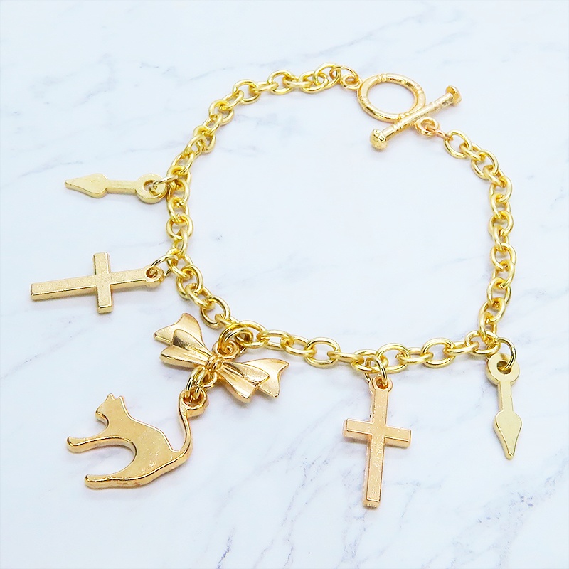 マットゴールドの猫シルエットモチーフとリボンに鍵と時計の針が連なるブレスレット