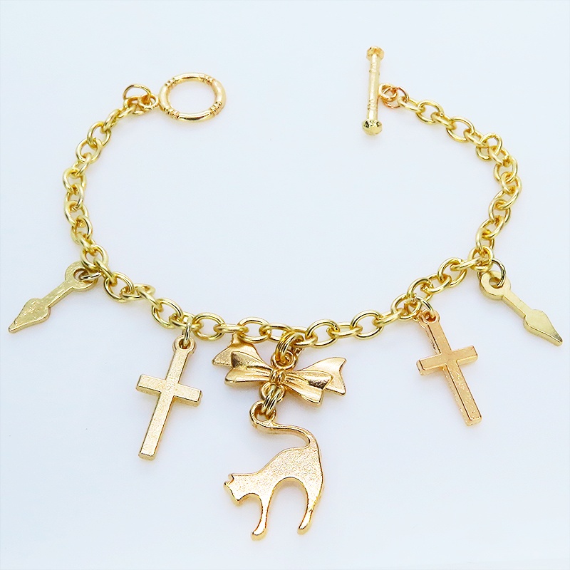 マットゴールドの猫シルエットモチーフとリボンに鍵と時計の針が連なるブレスレット