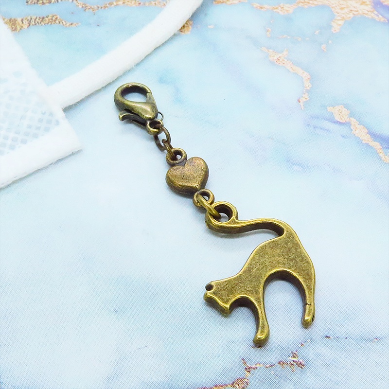 マスクチャーム アンティークゴールド 跳ね猫と小さなハートを組合せた大人可愛いチャーム