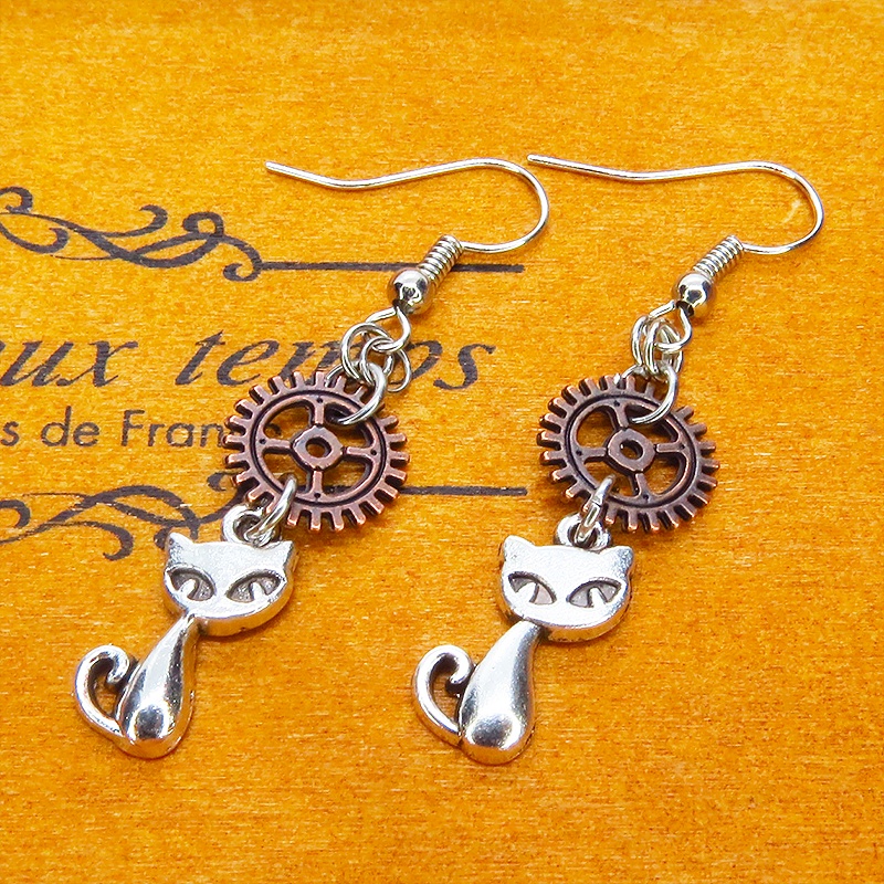 アンティークシルバーの猫とアンティークブロンズの歯車モチーフを組み合わせたコンパクトなピアス スチームパンク風