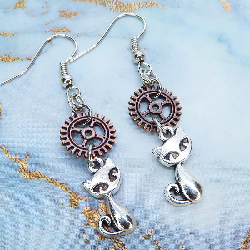 アンティークシルバーの猫とアンティークブロンズの歯車モチーフを組み合わせたコンパクトなピアス スチームパンク風
