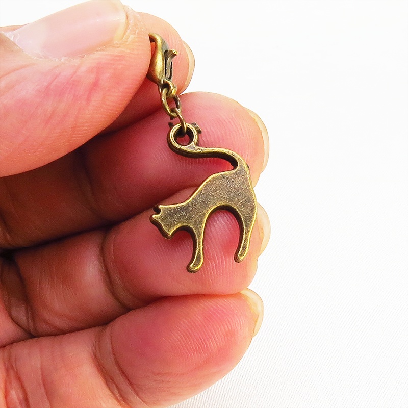 スマホ・マスクチャーム アンティークゴールド 跳ね猫モチーフのシンプルでコンパクトなチャーム ジャックピン追加可