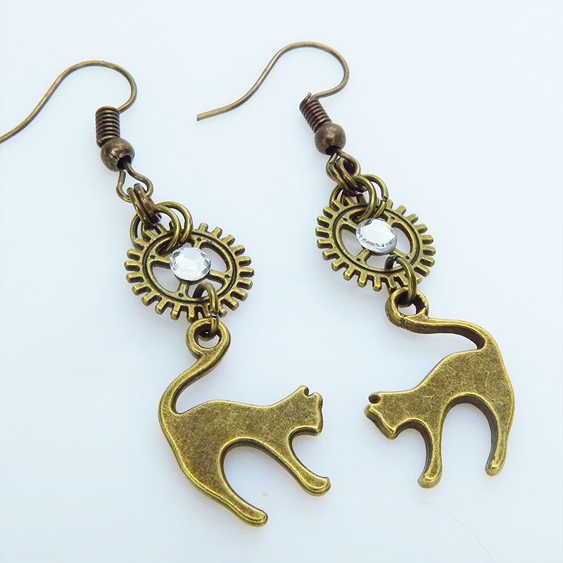 アンティークゴールド 跳ね猫モチーフと歯車を組合せたシンプルなピアス クリスタルガラス
