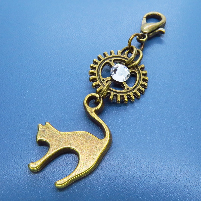 マスク・スマホチャーム アンティークゴールド 跳ね猫と歯車を組合せたチャーム ジャックピン追加可
