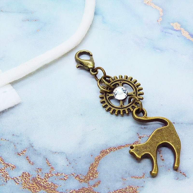 マスク・スマホチャーム アンティークゴールド 跳ね猫と歯車を組合せたチャーム ジャックピン追加可