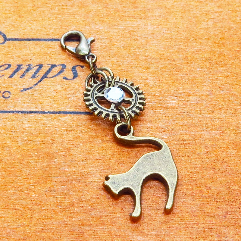 マスク・スマホチャーム アンティークゴールド 跳ね猫と歯車を組合せたチャーム ジャックピン追加可