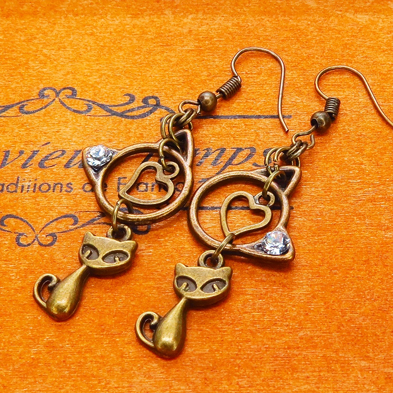 アンティークゴールド 猫モチーフと猫フェイスフレームのダブル猫ピアス スワロフスキークリスタル
