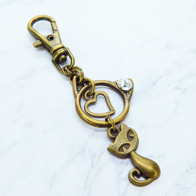 アンティークゴールド 猫モチーフと猫フェイスフレームのダブル猫キーホルダー スワロフスキークリスタル 金具変更可