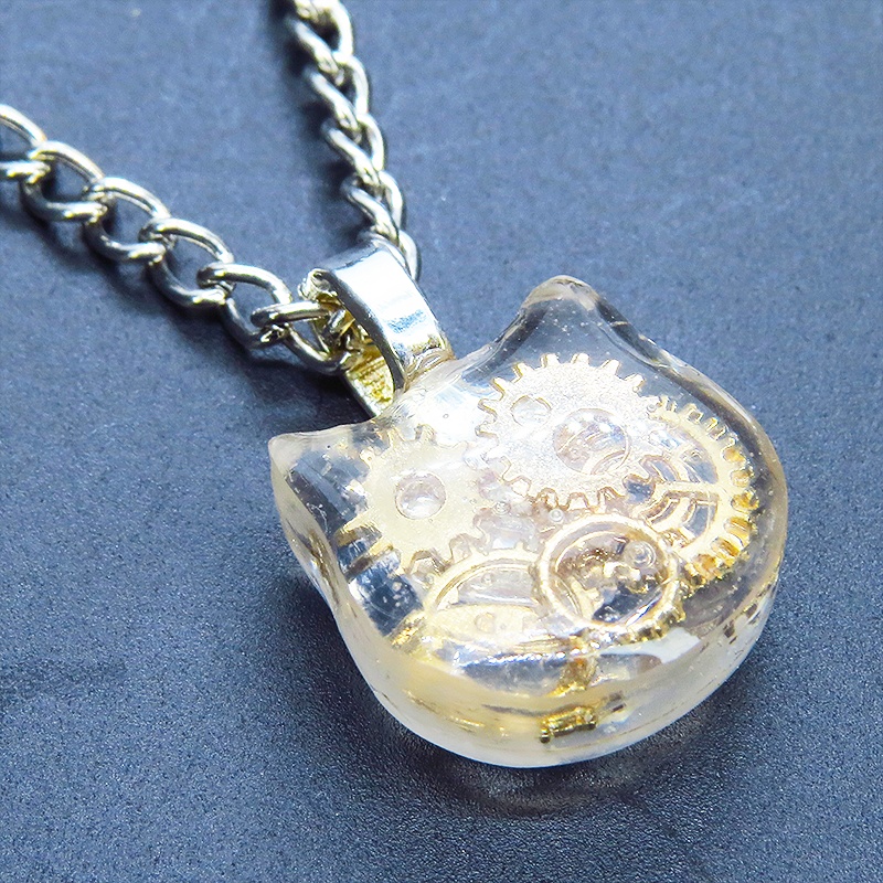 猫フェイスチャーム スチームパンク風 ゴールドカラーの歯車を封入したクリアレジンチャームネックレス 長さ調整可 アジャスター可